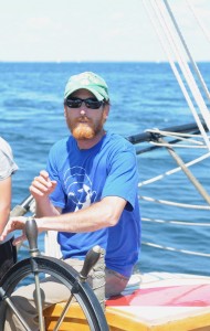 Captain Garth Wells at the helm of the Schooner Lewis R. French, the oldest vessel in the Maine Windjammer Association fleet, during the annual Parade of Sail in Rockland HArbor, Maine. Tom Nangle photo. 