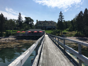 Red umbrellas provide shade so you can enjoy the views over Somes Sound while having lunch at The Boathouse at the Claremont in Southwest Harbor. ©Hilary Nangle