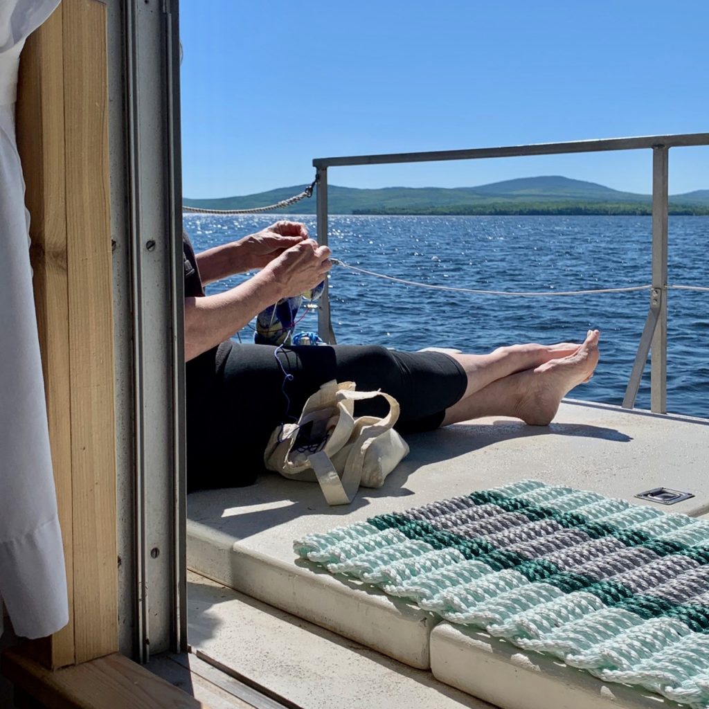 A knitter on the lower aft deck of the Floating Nomad