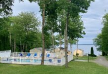 View taking in the pool, staggered cottages, and Penobscot Bay taken from above the lower pool at Glenmoor by the Sea.